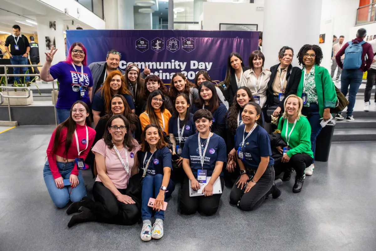 Grupo de asistentes posando frente al banner Community Day Argentina 2024