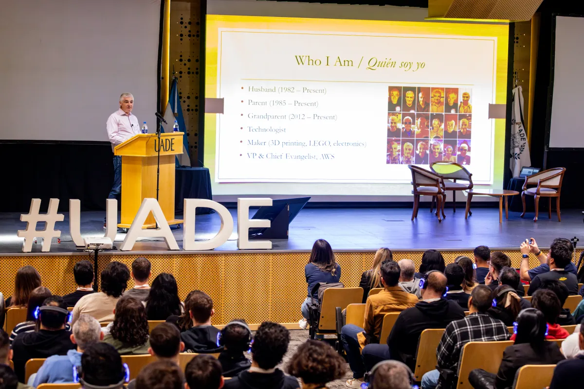 Speaker en podio UADE presentando ante audiencia llena